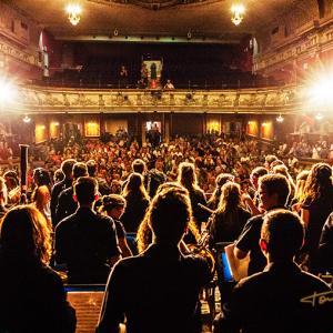 teatro olympia valencia banda musica juvenil sioam - Reportaje fotográfico a la Banda Juvenil SIOAM de Benimàmet en el Teatro Olympia de Valencia. Fotografía desde el fondo del escenario, contraplano de los músicos frente al público aplaudiendo. 